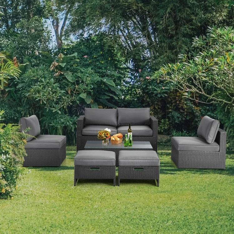 Cushioned rattan outdoor lounge seating arranged on a green backyard lawn