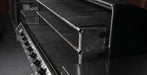 Close-up of a stainless steel gas grill showing the control knobs on the left and the interior grates and firebox chamber.