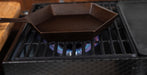 A dark cast iron octagonal pan sits on a gas stove burner with a blue flame visible underneath.