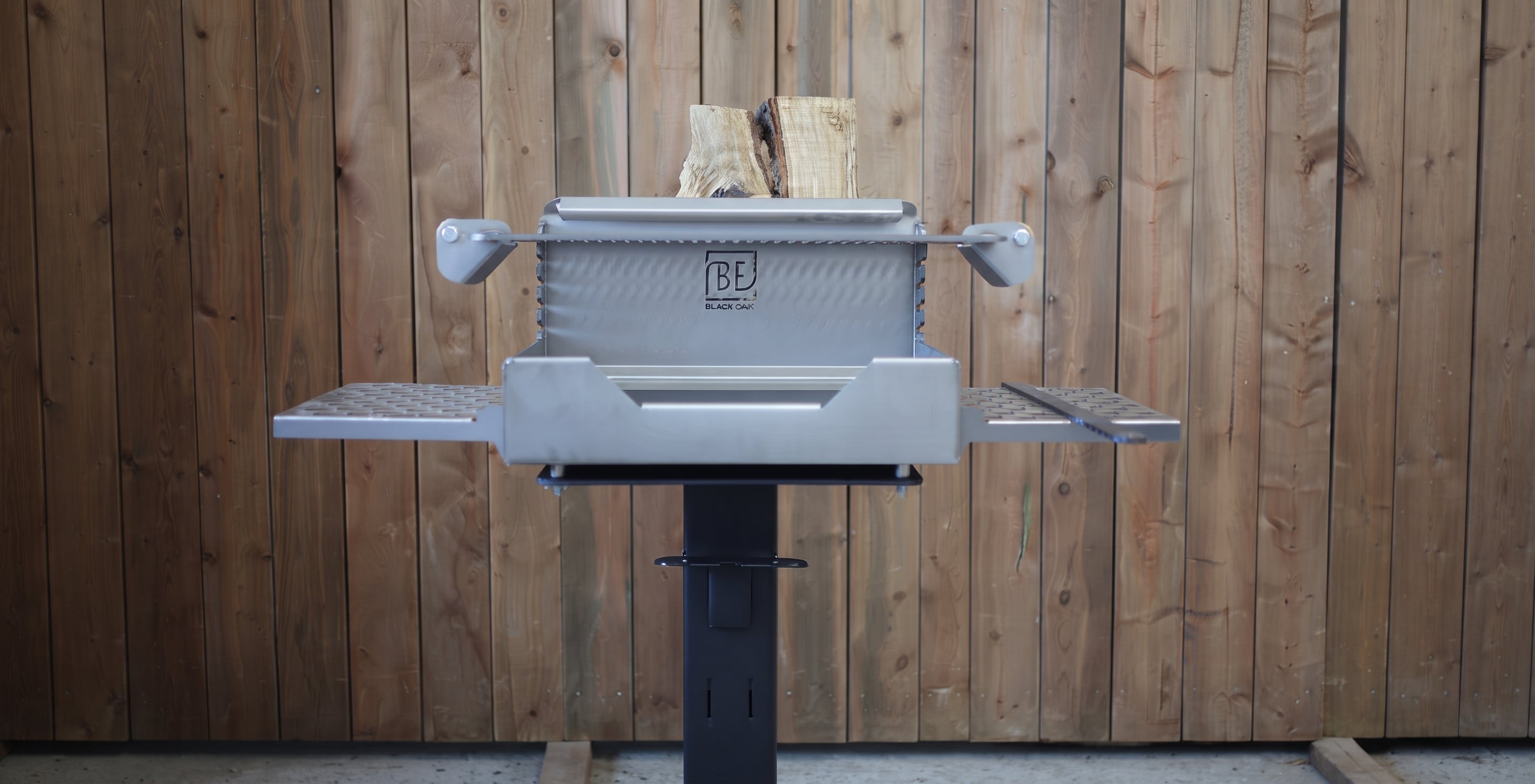 A gray and black outdoor a log loaded into the chamber, set against a vertical wooden plank wall.